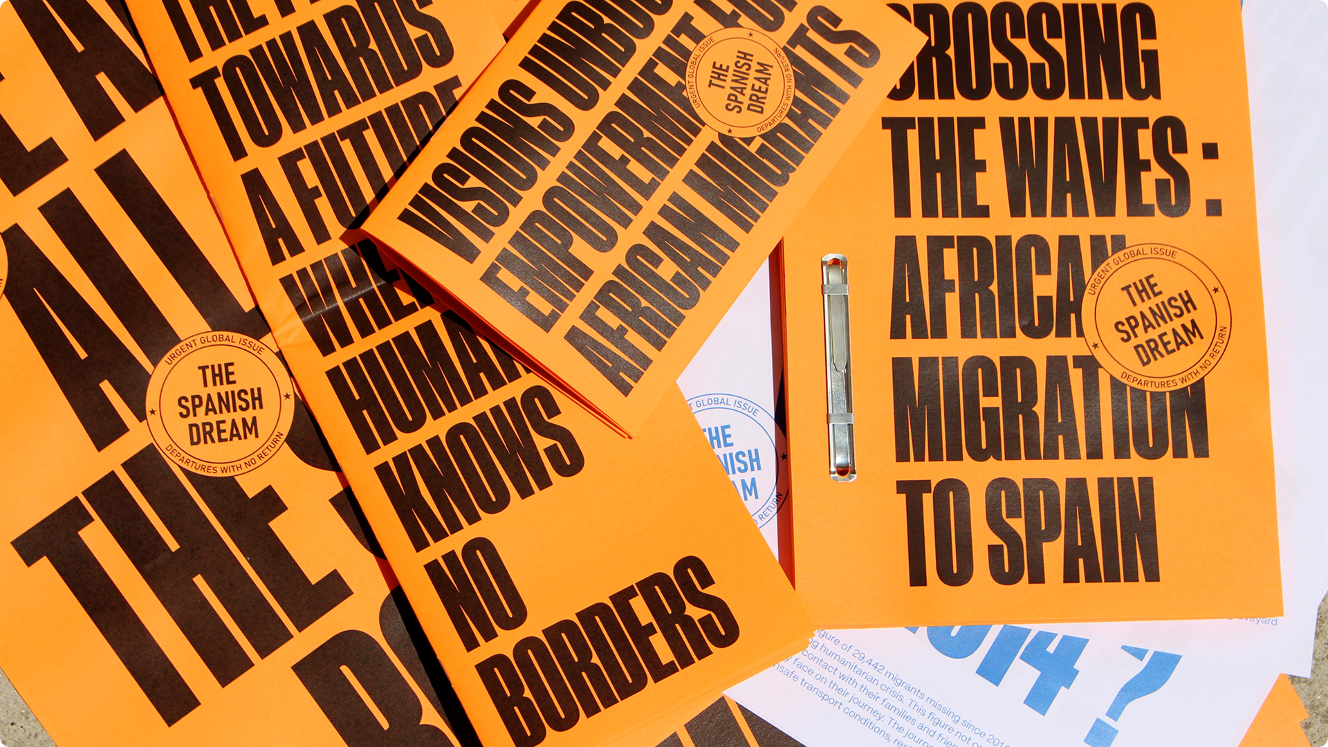 Colección de materiales impresos de color naranja con tipografía negra para el proyecto 'The Spanish Dream', enfocados en la migración africana.