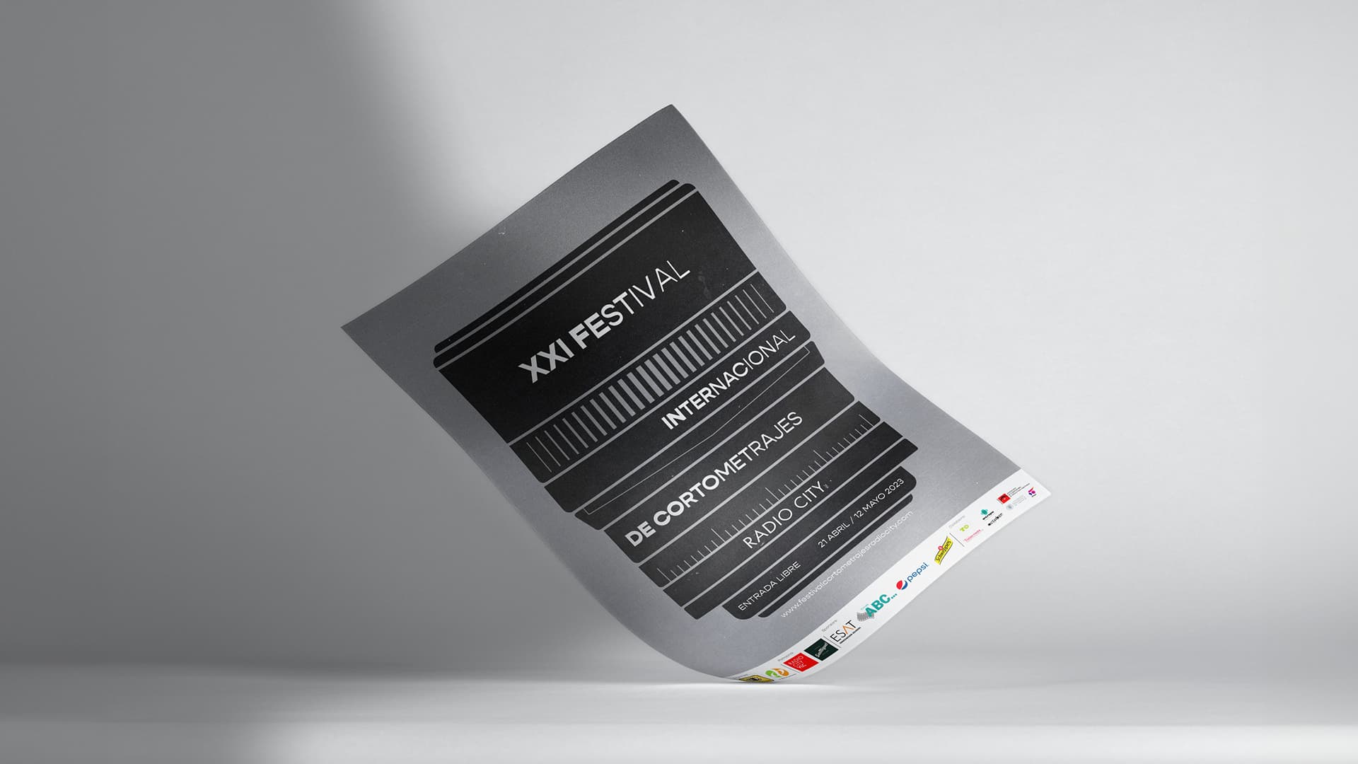 Mockup de un cartel plateado para el XXI Festival Internacional de Cortometrajes Radio City, con diseño tipográfico apilado.